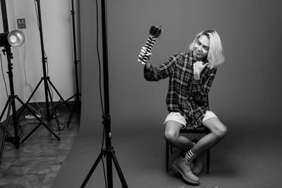 Full length portrait of young woman photographing