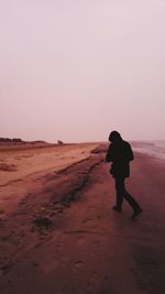 Rear view of woman walking in desert