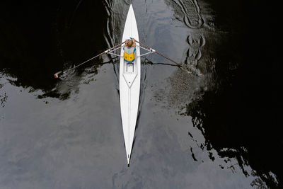 Rear view of man with umbrella on boat