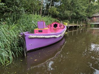 Boat moored on lake by trees