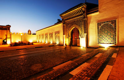 Illuminated building against sky at night