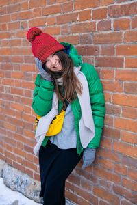 Full length of woman standing against wall