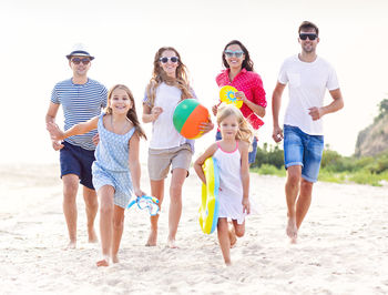 Full length of people walking on sand at beach