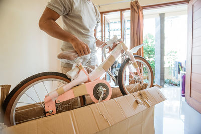 Man holding bicycle at home