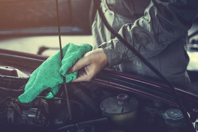 Close-up of mechanic cleaning car equipment