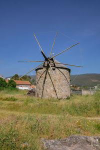 Traditional windmill on field against clear sky