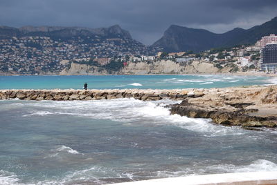 Person on groyne amidst sea