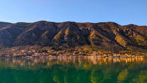 Scenic view of lake by mountains against clear sky