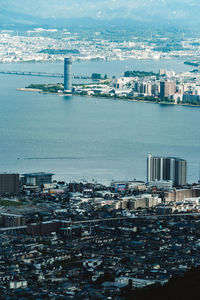 High angle view of buildings by sea against sky