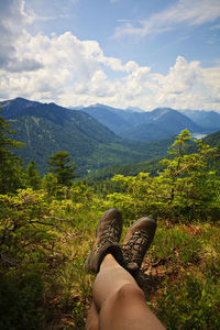 Low section of person on mountain against sky