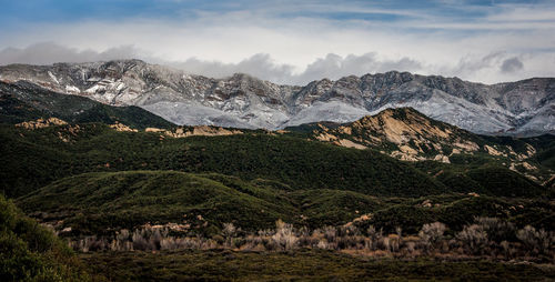 Scenic view of mountains against cloudy sky