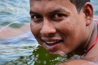 Close-up portrait of young man swimming in lake