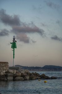 Lighthouse by sea against sky