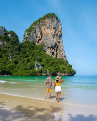 Rear view of couple walking on beach