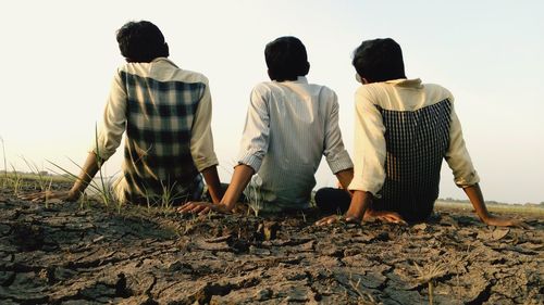 Rear view of people standing on beach