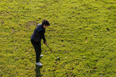 Aerial view on a golfer taking a shot on fairway.