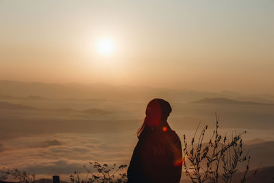 Rear view of woman looking at sunset