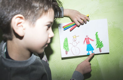 Full length portrait of boy holding paper