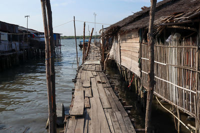 Wooden pier over canal amidst buildings against sky