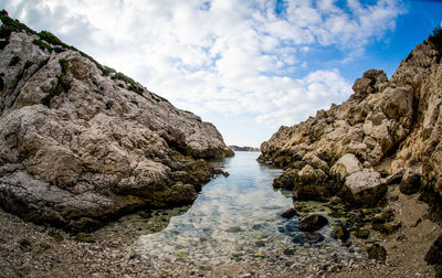 View of rocky beach against clouds