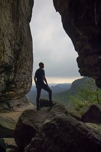 Full length of man standing on rock against sky