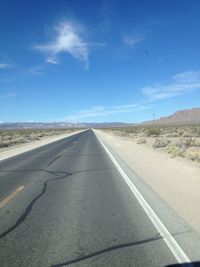 Road passing through landscape against blue sky