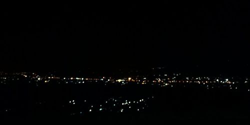 Illuminated city against clear sky at night