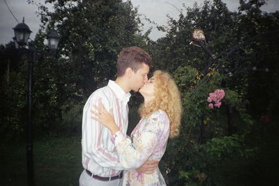 Young couple standing by flowering tree