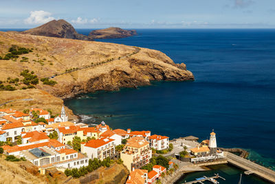 High angle view of townscape by sea against sky