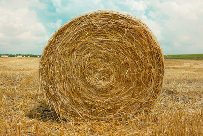 Hay bales on field against sky