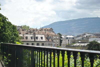 Buildings in town against cloudy sky