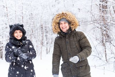 Portrait of smiling woman standing in snow