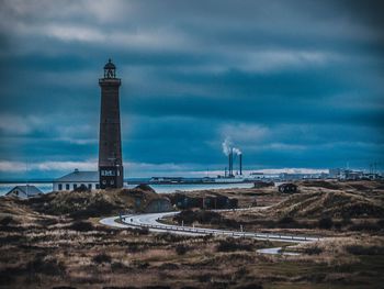 Lighthouse amidst buildings against sky