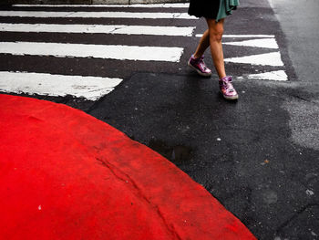 Low section of woman walking on road