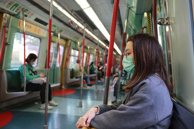 Full length of woman sitting in train