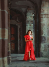 Full length of beautiful woman standing in building corridor