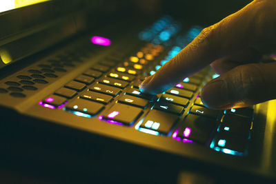 Close-up of hand using illuminated computer keyboard