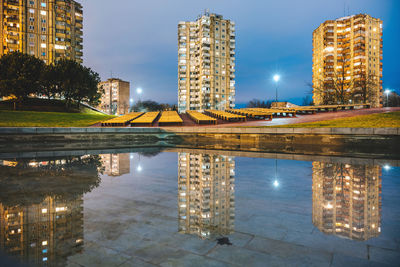 Reflection of illuminated buildings in city at night