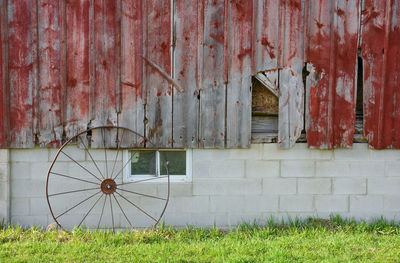 Rusty metal on field against building