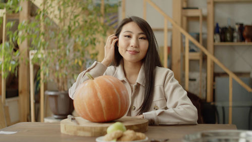 Portrait of young woman holding pumpkin