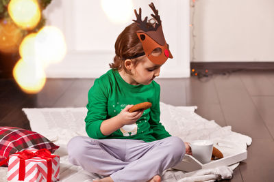 Side view of young woman sitting on sofa at home