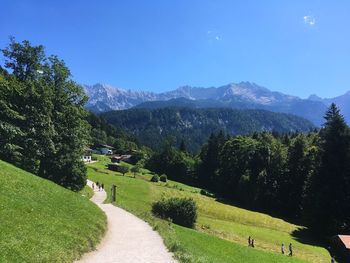 Scenic view of field by mountains against sky