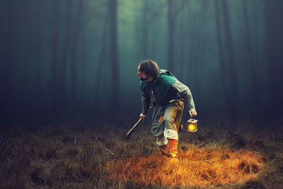 Full length of man standing by tree in forest