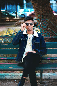 Portrait of young man sitting on bench