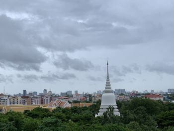 Buildings in city against cloudy sky