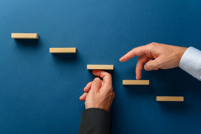 High angle view of hand holding toy against blue background