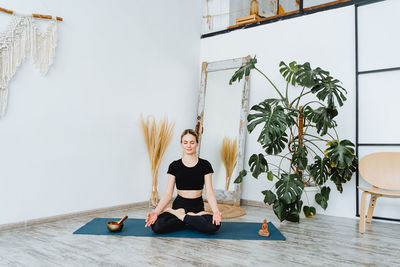 Full length of young woman sitting in sea