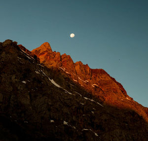 Low angle view of rocky mountains against clear sky