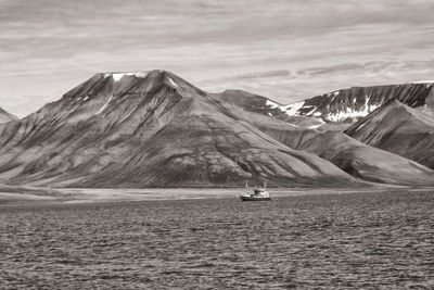 Steamboat on sea against mountains, svalbard coast