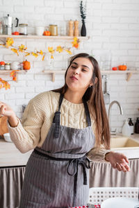 Portrait of young woman standing at home